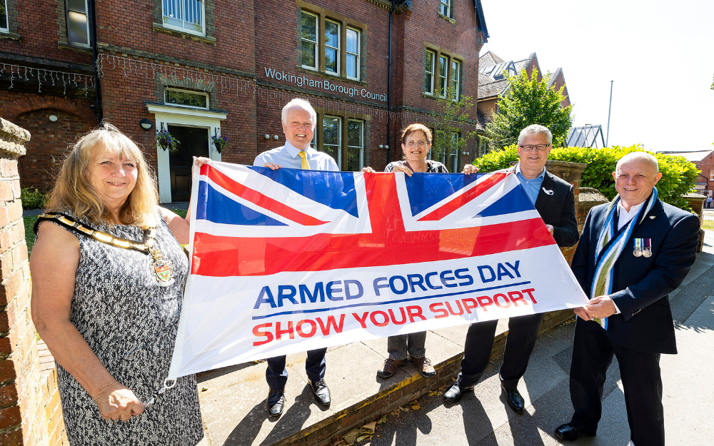 Wokingham Borough Mayor Cllr Smith holds the Armed Forces Day flag outside our Shute End office with other councillors