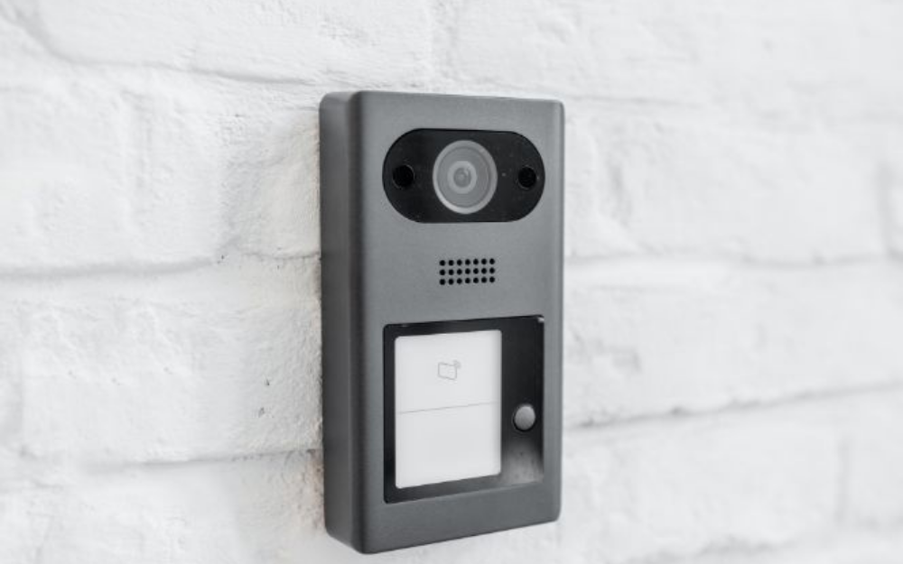 A home security camera doorbell attached to an external wall