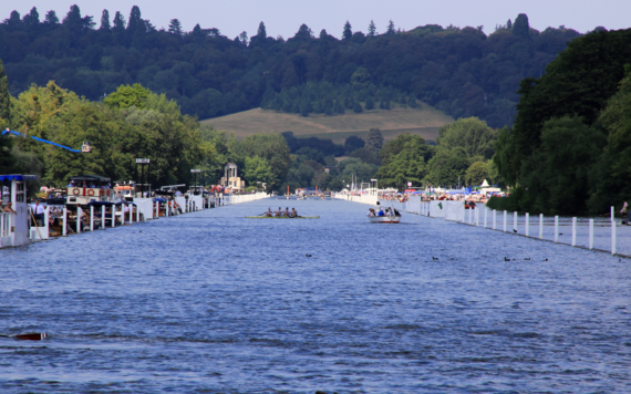 A view down the river of Henley Regatta with boats on the river and crowds at the side