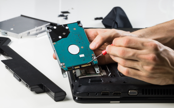 A man repairing a circuit board from a laptop 