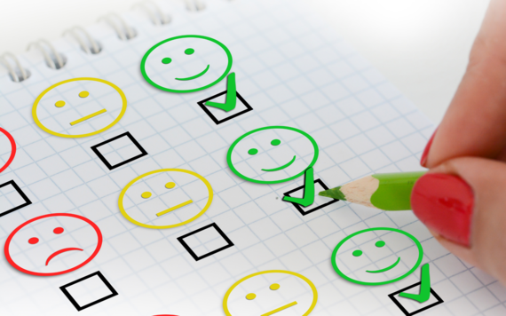 A survey form with choices of red sad faces, yellow faces with a neutral look and green happy faces with ticks in the boxes underneath