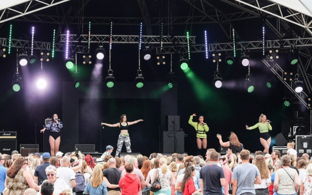 A band perform on stage at Marvellous Festival, hundreds watch on