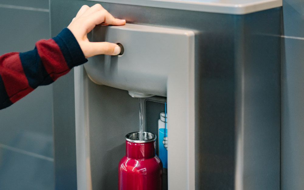 A water bottle being filled from a fountain