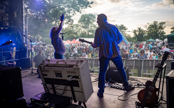 A band plays on the main stage at Wokingham Festival, the crowd watches on