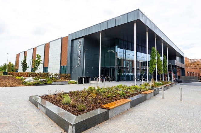 external shot of Carnival Hub, with planting troughs and benches outside in foreground, on the opening day