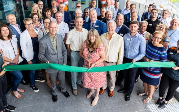 A large group of guests gathered around the Borough Mayor as she cuts a ribbon at the new Wokingham Leisure Centre