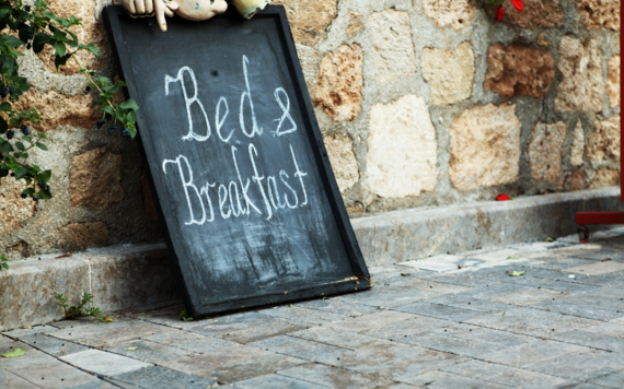 A photo of a blackboard reading bed and breakfast by the wall