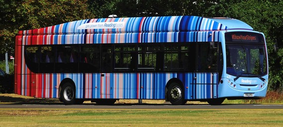 A single-decker bus decorated with blue and red vertical stripes representing a human-made increase in temperatures