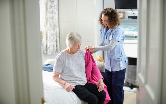 Carer helping an elderly lady get dressed