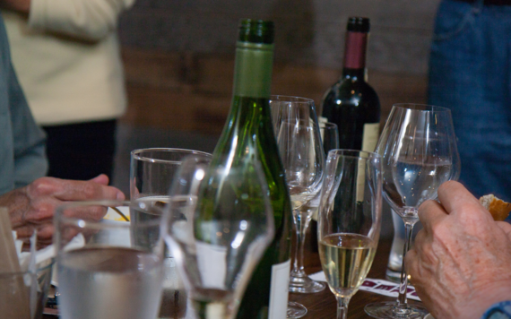 Some wine bottles and drinking glass on the table