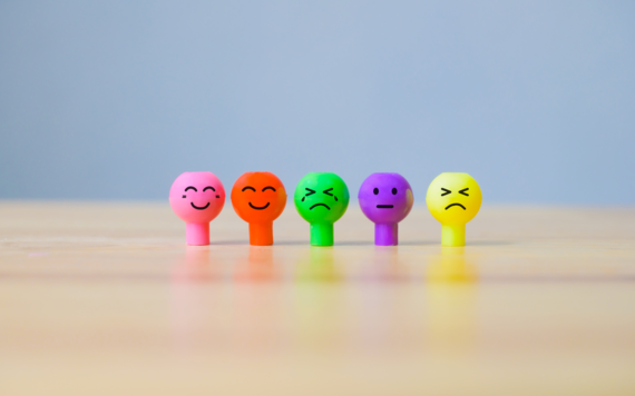 Multiple coloured pins each expressing a different emotion