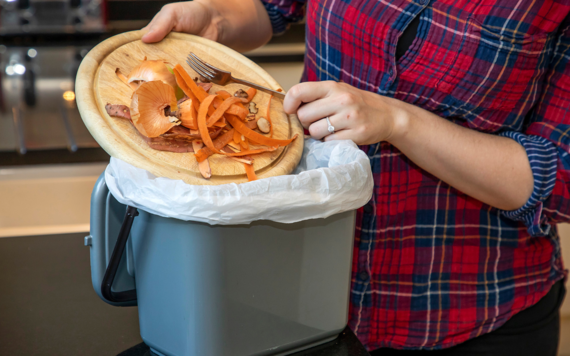 Some kitchen scraps are being put into an indoor food waste caddy
