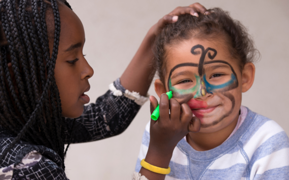 Woman painting a young boy's face