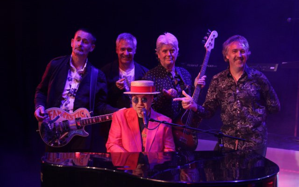 Ultimate Elton John and the Rocket Band behind a piano