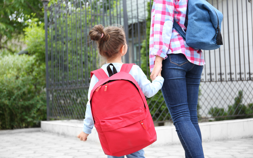 A parent walks into school with their daughter