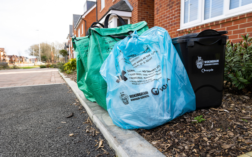 Blue waste bag, green recycling bag and a food waste caddy at the kerbside in Wokingham Borough