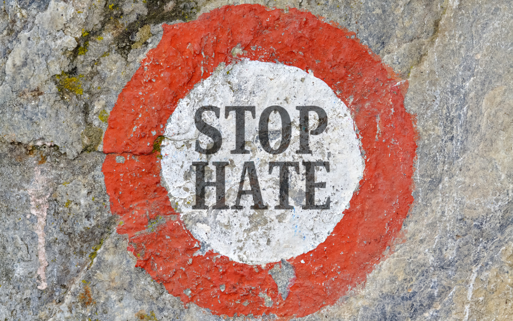 A stop sign on tarmac, with the words 'stop hate' in the centre