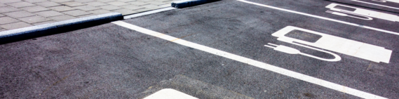 photo of parking bays with an electric charger symbol painted on the asphalt