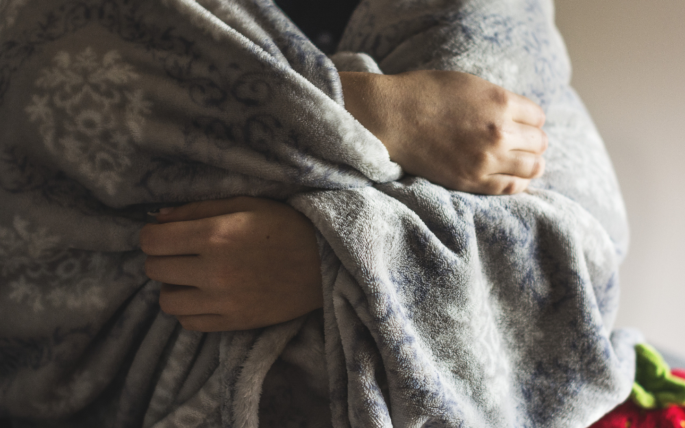 A person wrapped in a blanket to keep them warm