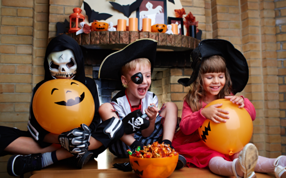 Three children dressed in Halloween costumes