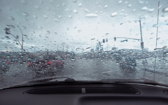 View out a windscreen of a car, with heavy rain making it hard to be see cars in front