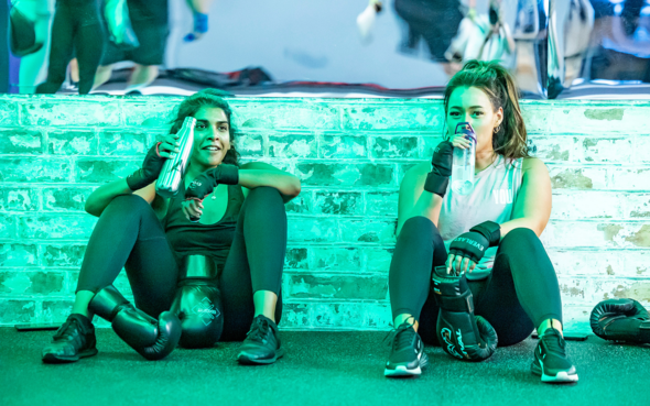 Two girls sitting down after a boxing workout