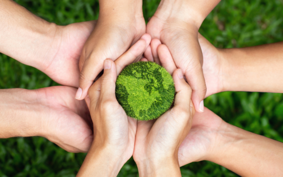 Hands holding a green Earth