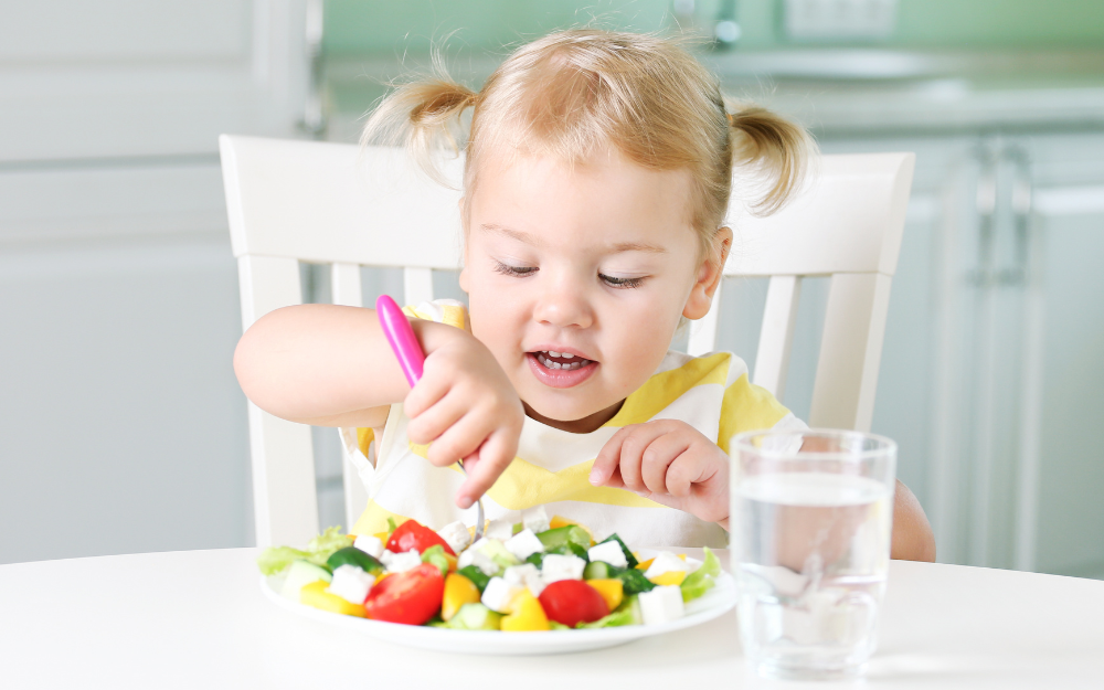 A young child tucks into a health lunch at the dinner table