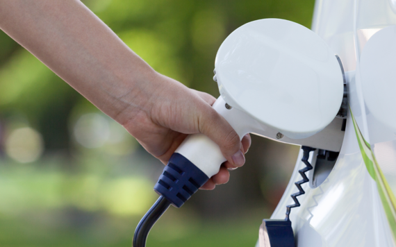 White car being charged by an EV charger