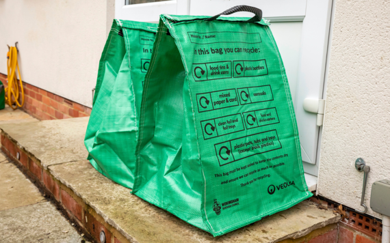 Two green recycling bags at the doorsteps