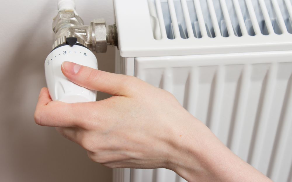 Someone adjusting the temperature on a radiator