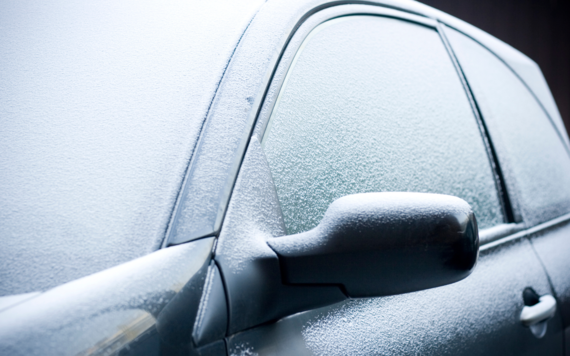 A car front window and side covered in frost after a cold night