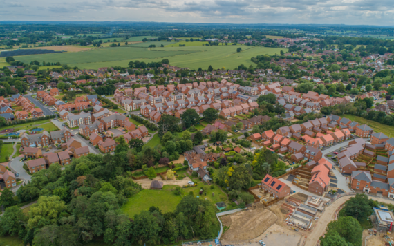 New housing under construction from an aerial drone image, showing construction still ongoing, green space around it