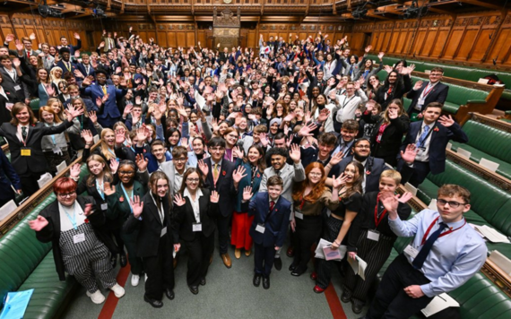 Hundreds of Members of Youth Parliament on and around the green benches of the House of Commons