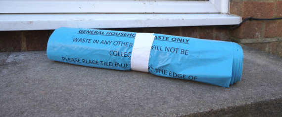 a roll of blue bags on a doorstep
