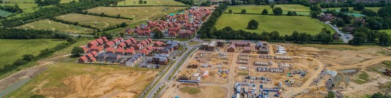 aerial view of new housing being built, with part of the site still untouched