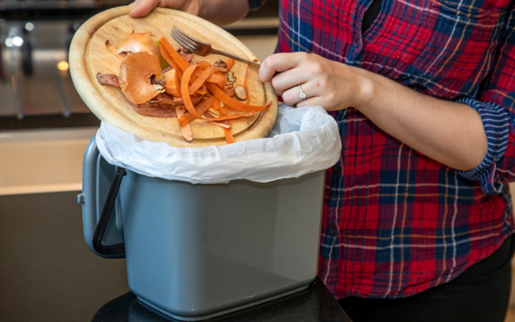 Food scraps being put into a kitchen caddy