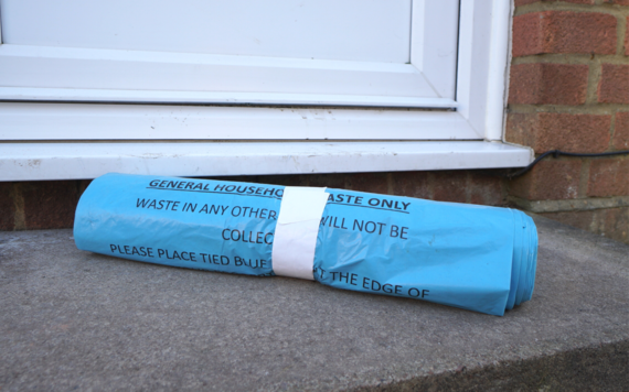 A roll of blue general rubbish bag on doorstep