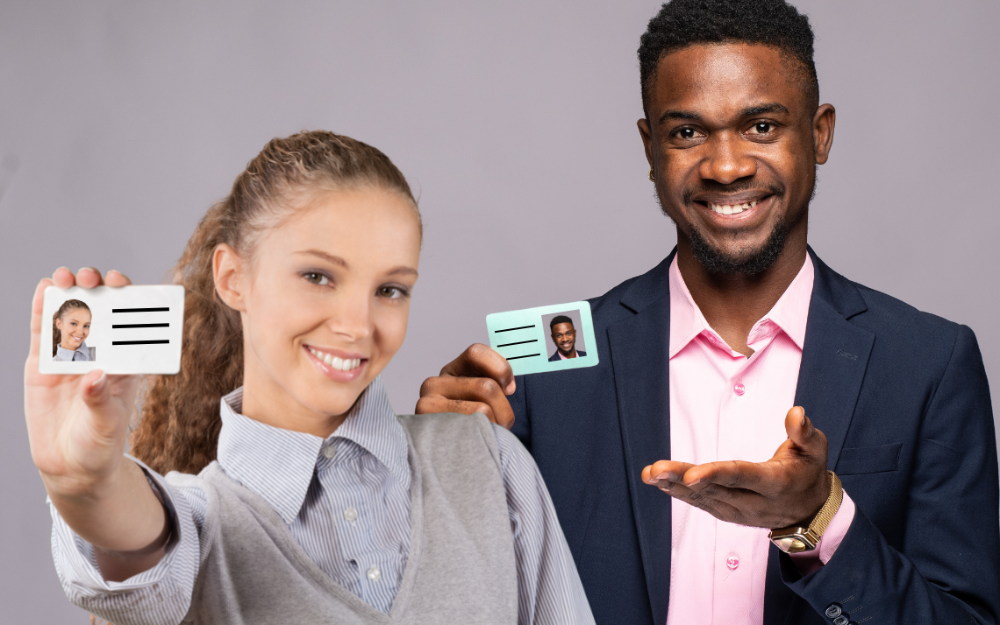 A man and a woman hold out voter IDs