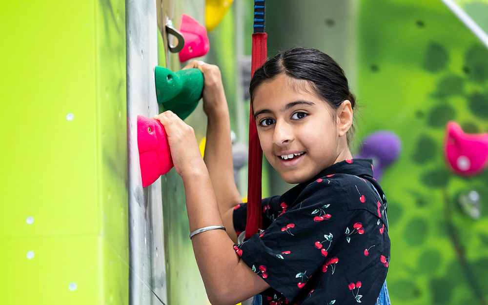 A young girl on the climbing wall at Dinton Activity Centre