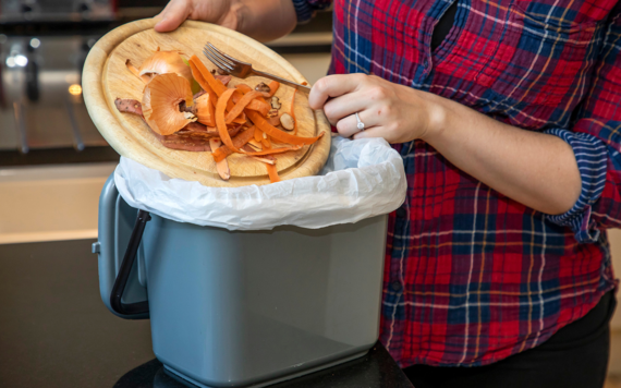 Food scraps being put into a kitchen caddy
