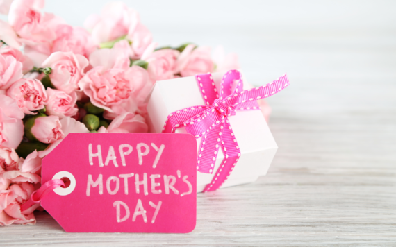 A bouquet of pink roses with a card reading Happy Mothers' Day