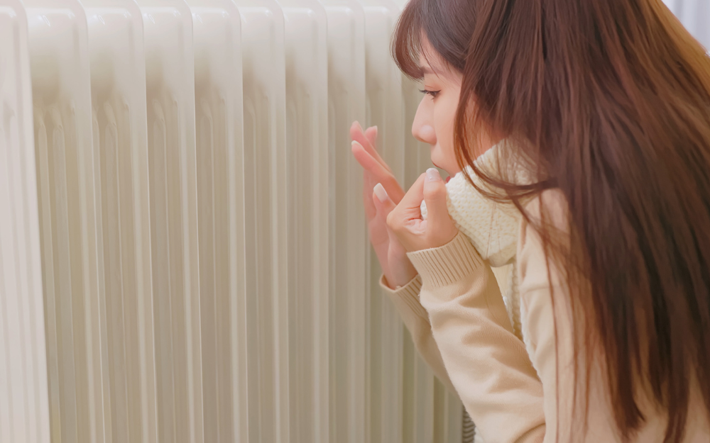 Person keeping warm by the radiator