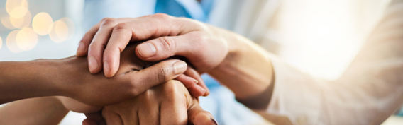 Close up of hands on top of each other, signifying support