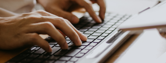 close up of fingers typing on a computer keyboard