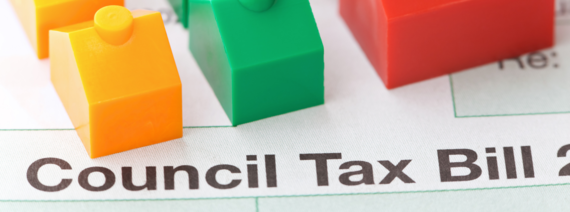 close up of a council tax bill with small plastic houses on top of it