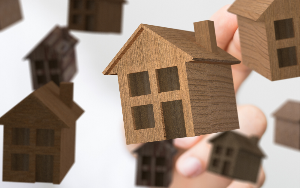 A small wooden house alongside a background set of more small wooden houses