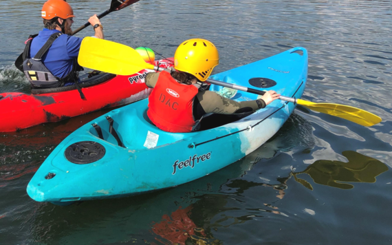 A photo showing the back of two people kayaking