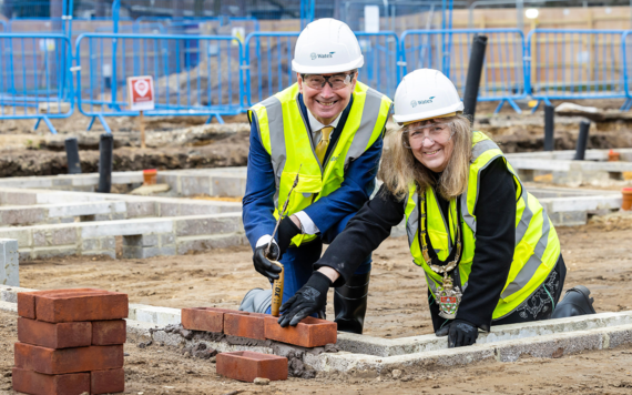 Cllr Caroline SMith and Cllr Stephen Conway lay bricks at Gorse Ride to mark the next stage of construction