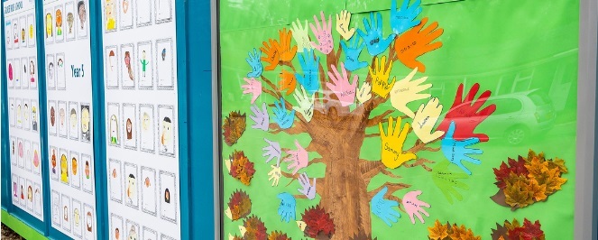A children's artwork, displayed in public, featuring a tree with "leaves" made up of coloured hand prints